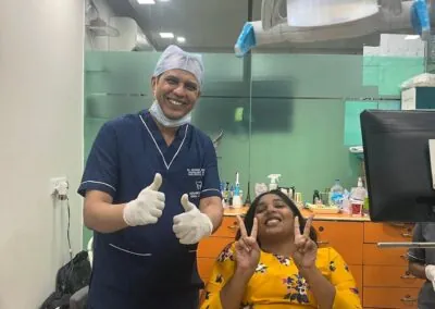 Patient in the dental chair celebrating with the surgeon after treatment